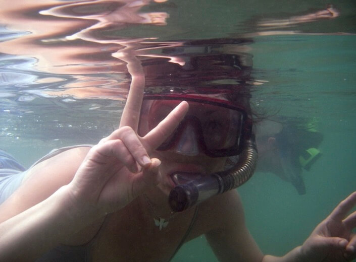 Snorkeling Snorkeling student gives a peace sign underwater to camera.