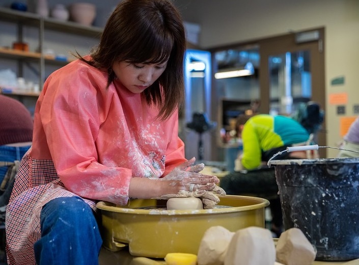 Pottery Female student of Asian descent creates a piece of pottery out of clay.