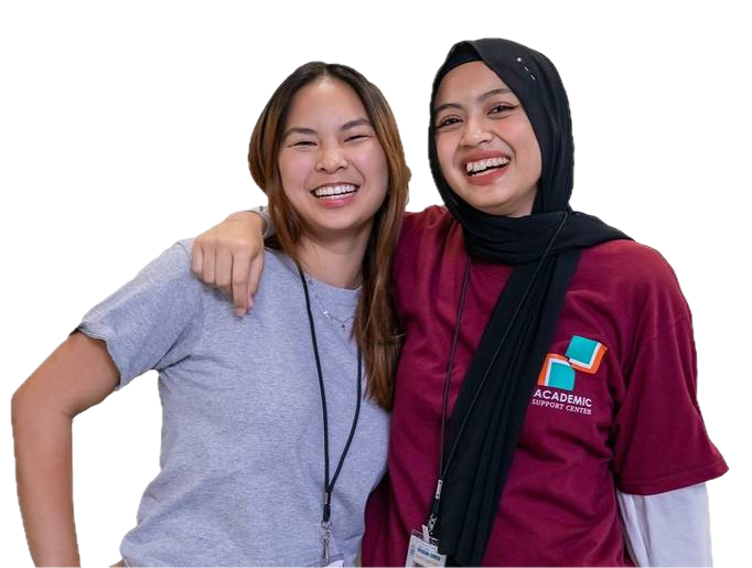 Two girls with their arms flung around each other. One is Middle-Eastern and wears a hijab and the other is of Asian descent.