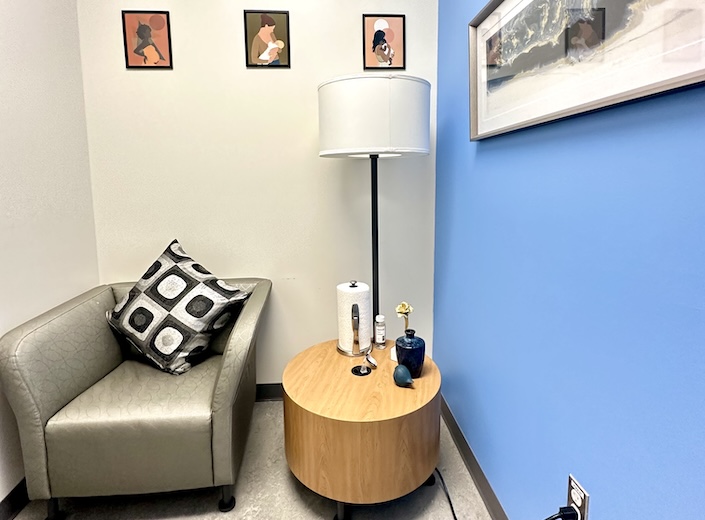 Lactation room. Lactation room with chair, table, lamp, and artwork featuring nursing mothers.