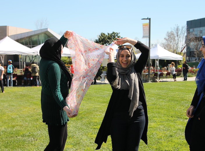 Headscarves Two women in head scarves dance playfully on the Central Plaza during a college event.