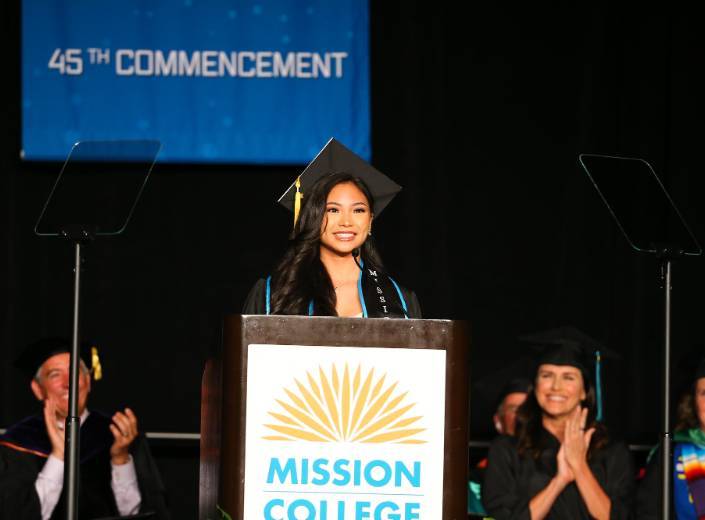 Commencement Young woman at commencement in cap and gown. She is of Asian-American descent and has long shiny black hair.