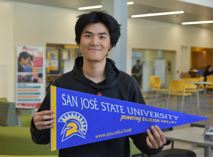 Student holds CSU pendant.